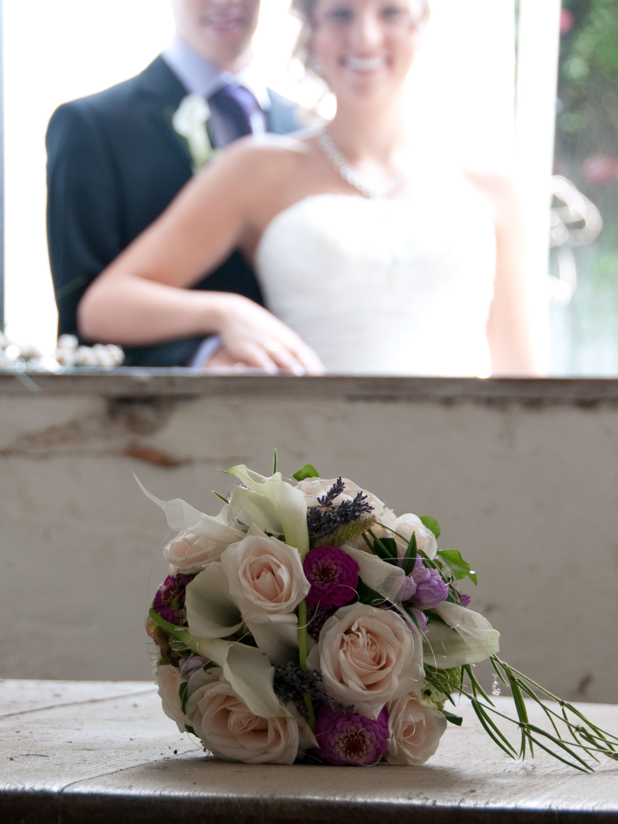 Hochzeitsehepaar mit Brautstrauss im Vordergrund